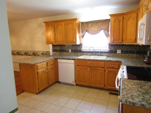 kitchen featuring sink, kitchen peninsula, white appliances, decorative backsplash, and light tile patterned floors