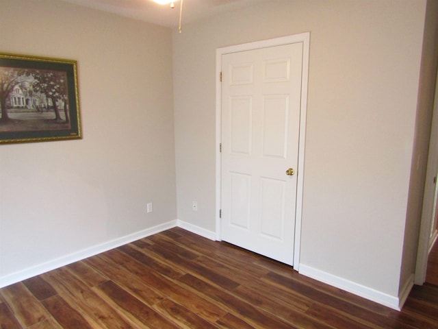 empty room with dark hardwood / wood-style flooring