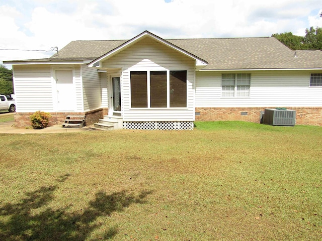 rear view of house featuring cooling unit and a yard