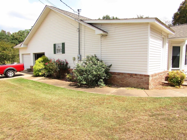 view of side of property featuring a garage and a yard