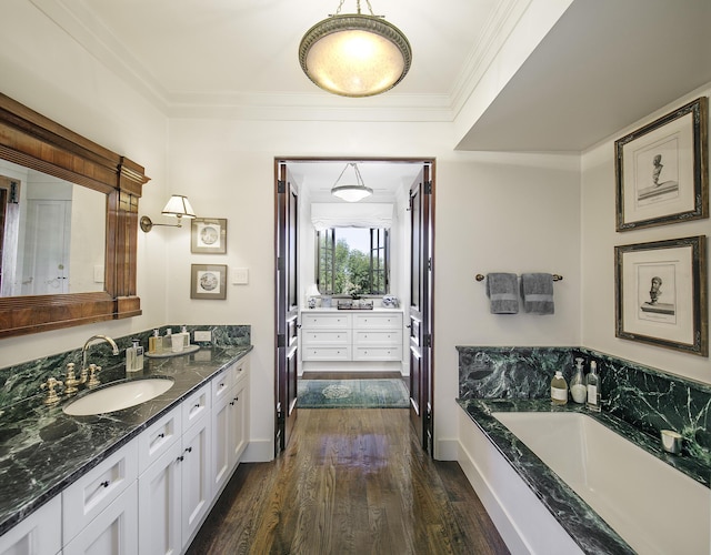 bathroom featuring a tub to relax in, crown molding, hardwood / wood-style floors, and vanity