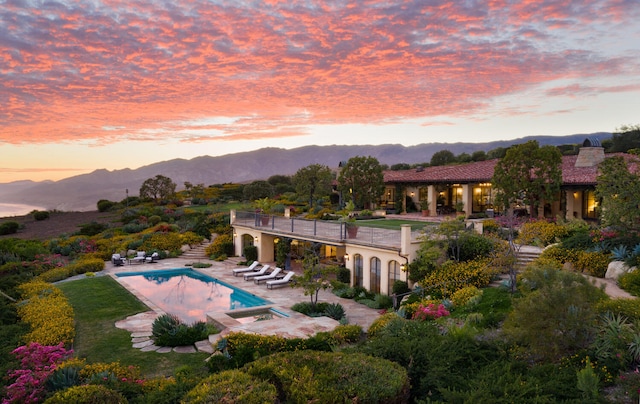 pool at dusk with a patio area