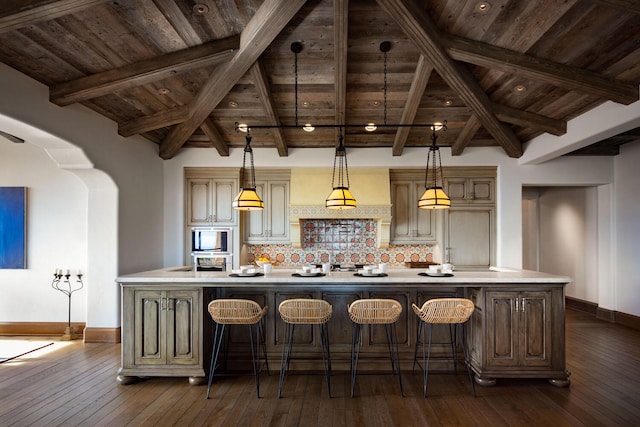 kitchen featuring decorative light fixtures, an island with sink, stainless steel appliances, wood ceiling, and tasteful backsplash