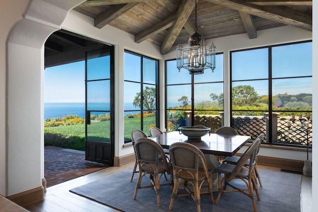 sunroom / solarium with a water view, wooden ceiling, vaulted ceiling with beams, and a chandelier