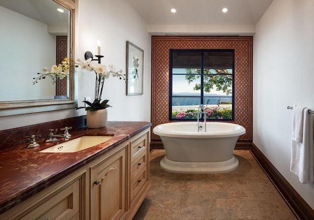 bathroom with vanity, a bath, and tile flooring