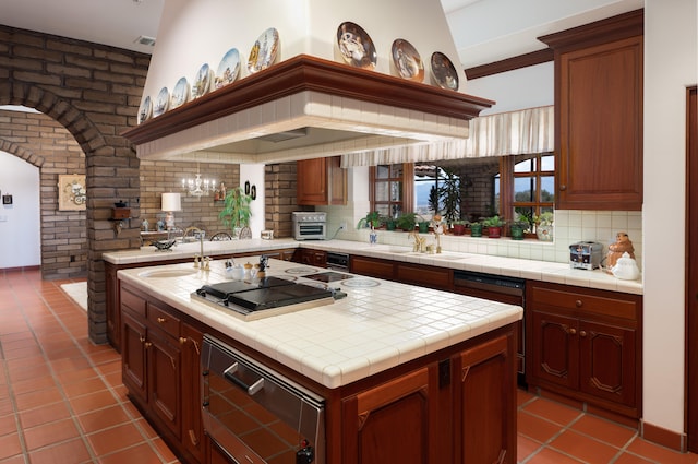 kitchen featuring light tile flooring, lofted ceiling, backsplash, tile counters, and a chandelier