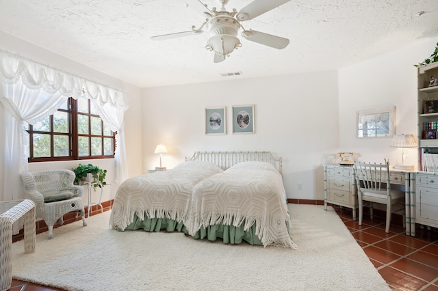 bedroom featuring dark tile floors, a textured ceiling, and ceiling fan