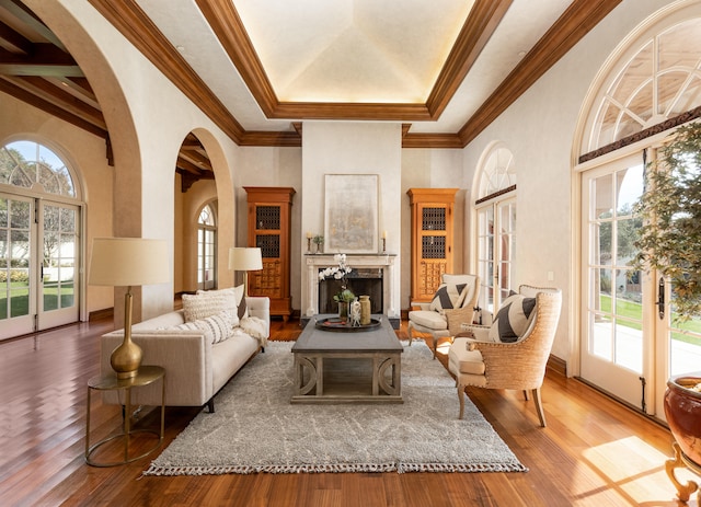 living room with a raised ceiling, ornamental molding, and hardwood / wood-style flooring