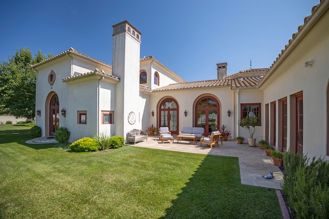 rear view of property with a patio area, a lawn, outdoor lounge area, and french doors