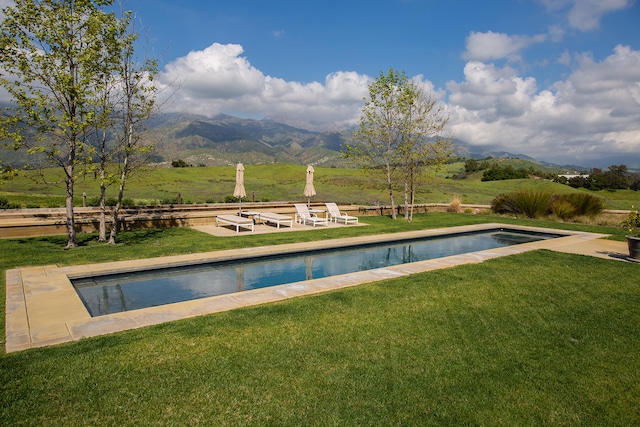 view of pool featuring a mountain view and a yard