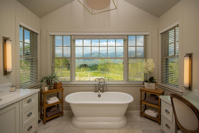 bathroom featuring lofted ceiling, tile floors, a bathtub, and vanity