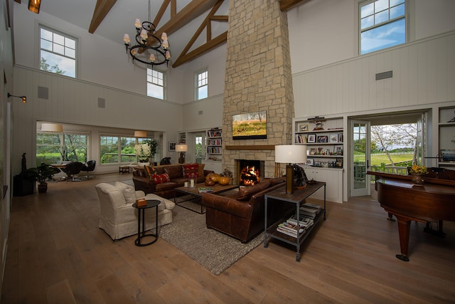 living room with a stone fireplace, high vaulted ceiling, and wood-type flooring