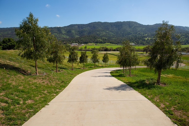 view of nearby features featuring a mountain view, a yard, and a rural view