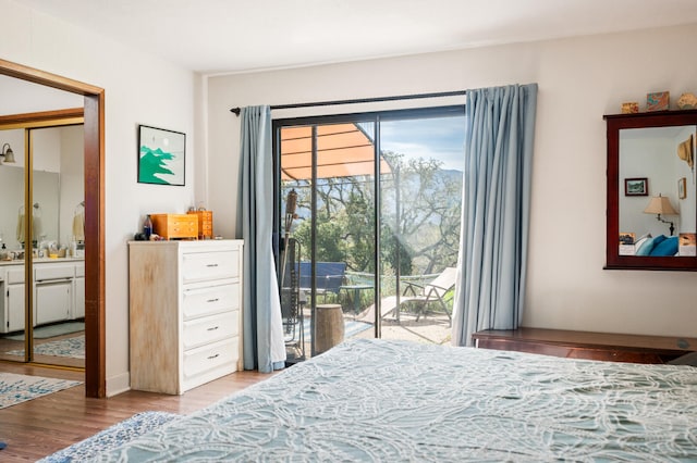 bedroom featuring access to exterior and wood finished floors
