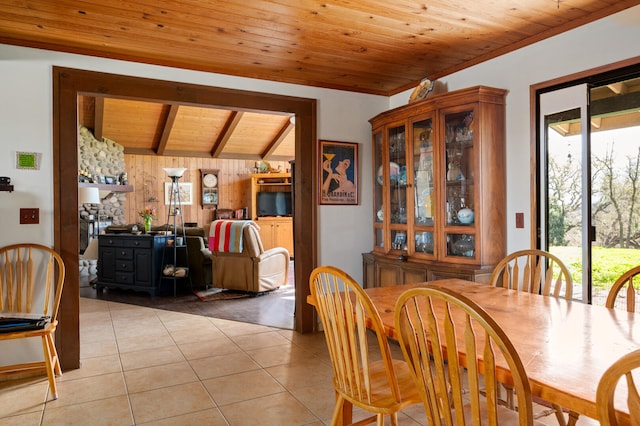 dining area with lofted ceiling with beams, wood ceiling, and light tile patterned floors