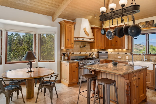 kitchen with stainless steel stove, backsplash, custom range hood, and wood ceiling