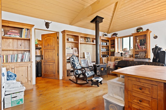 misc room featuring wooden ceiling, lofted ceiling, a wood stove, and light hardwood / wood-style flooring