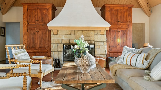 living room featuring a stone fireplace, vaulted ceiling with beams, and wood finished floors
