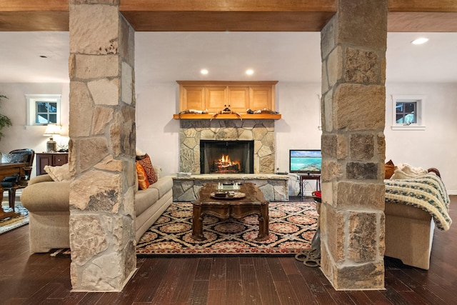 living room with dark hardwood / wood-style floors, beam ceiling, and a fireplace