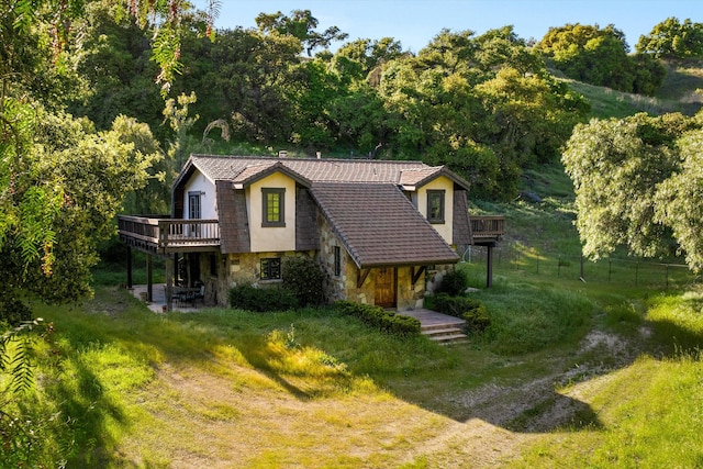 view of front facade with a wooden deck and a front lawn