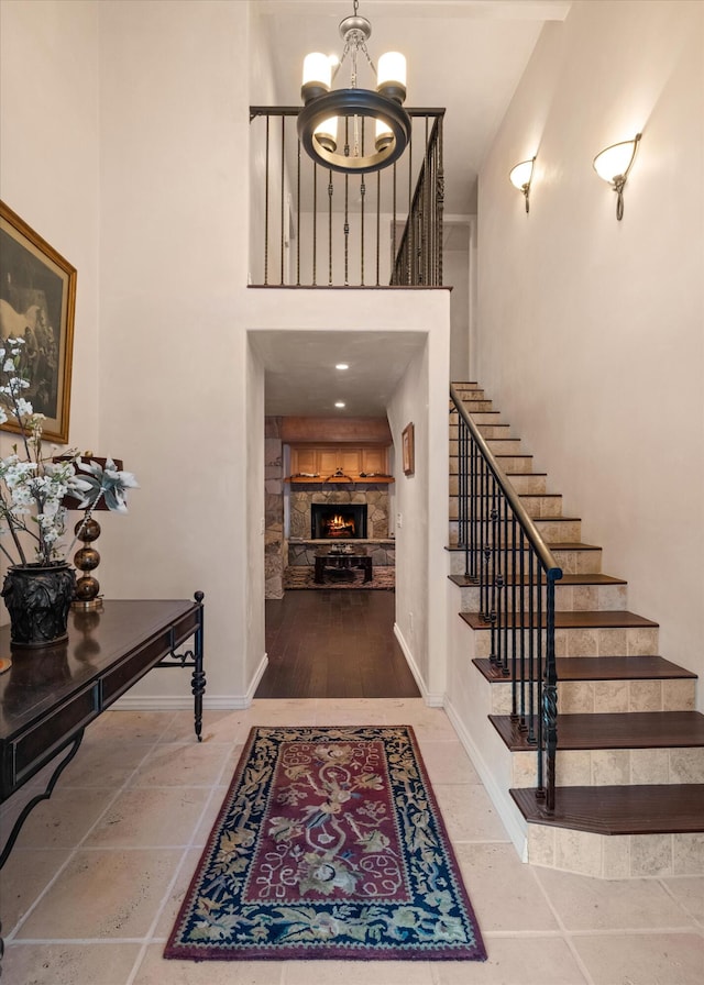 entrance foyer with a towering ceiling, tile floors, and an inviting chandelier