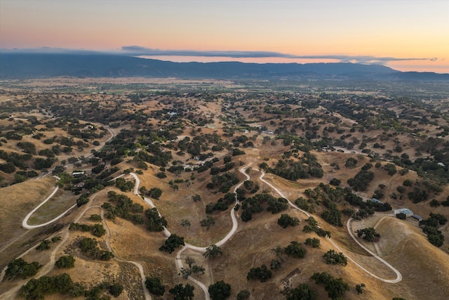 aerial view at dusk featuring a mountain view