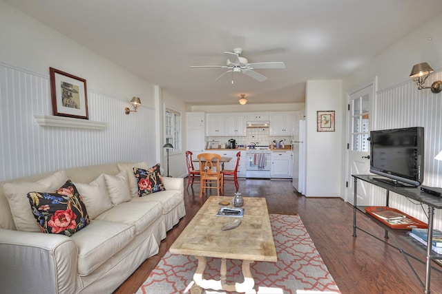 living room featuring dark wood-type flooring and ceiling fan