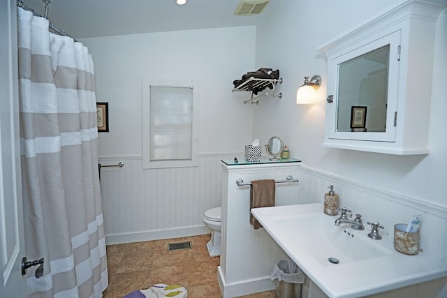 bathroom with toilet, tile floors, and sink