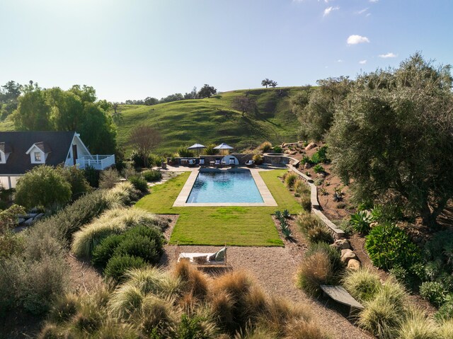 view of swimming pool featuring a yard and a rural view