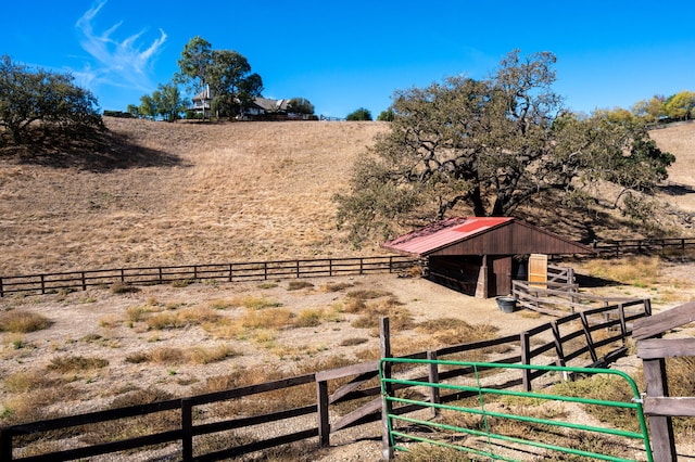 view of yard featuring a rural view and a storage shed