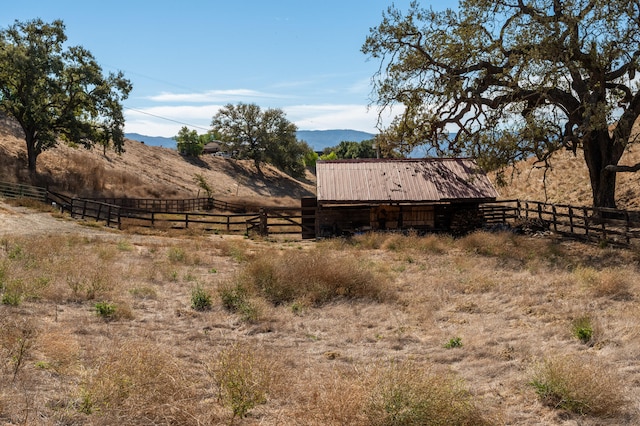 view of yard with a rural view and a mountain view