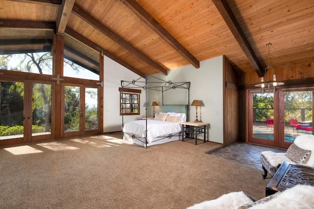 unfurnished bedroom featuring a notable chandelier, beam ceiling, multiple windows, and french doors