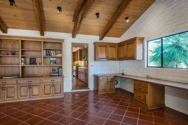 unfurnished office featuring built in desk, wooden ceiling, vaulted ceiling with beams, and dark tile floors