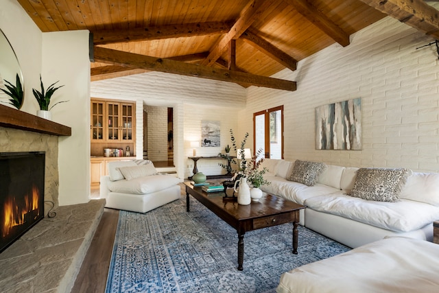 living room with brick wall, wooden ceiling, dark wood-type flooring, and lofted ceiling with beams