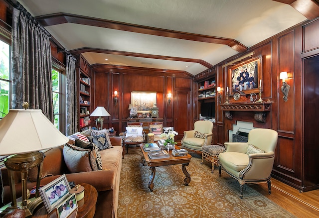 living room with wooden walls, lofted ceiling with beams, wood-type flooring, and built in shelves