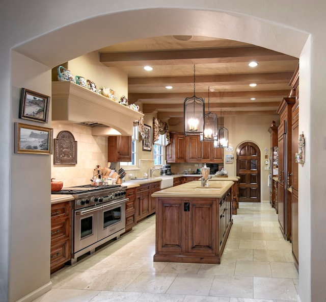 kitchen featuring butcher block countertops, a center island, double oven range, tasteful backsplash, and hanging light fixtures