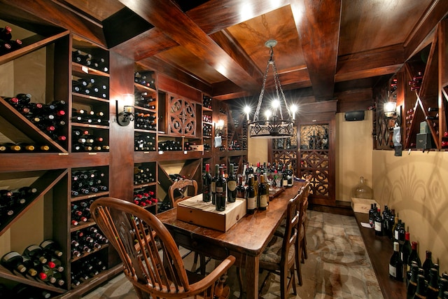 wine cellar featuring dark tile flooring, wood ceiling, coffered ceiling, and a chandelier