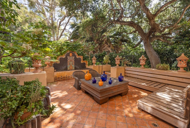 view of terrace with an outdoor fireplace