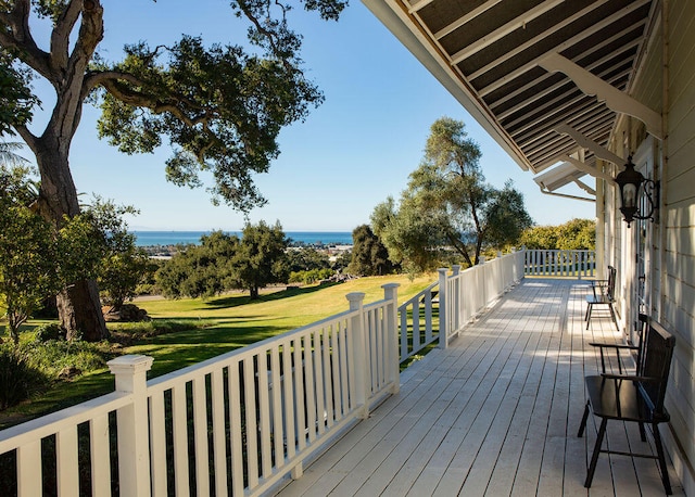 deck with a yard and a water view