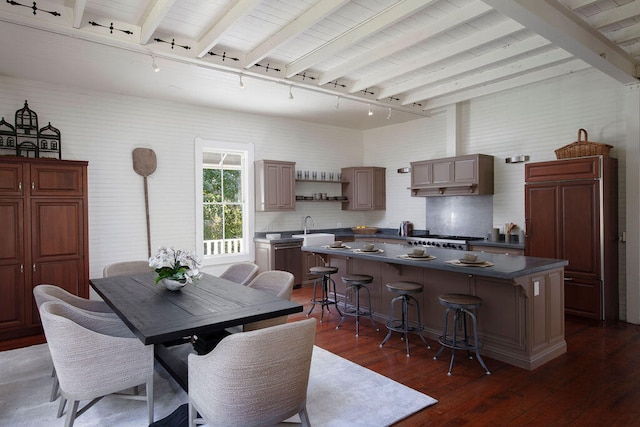 dining room featuring beam ceiling, dark hardwood / wood-style flooring, sink, and track lighting