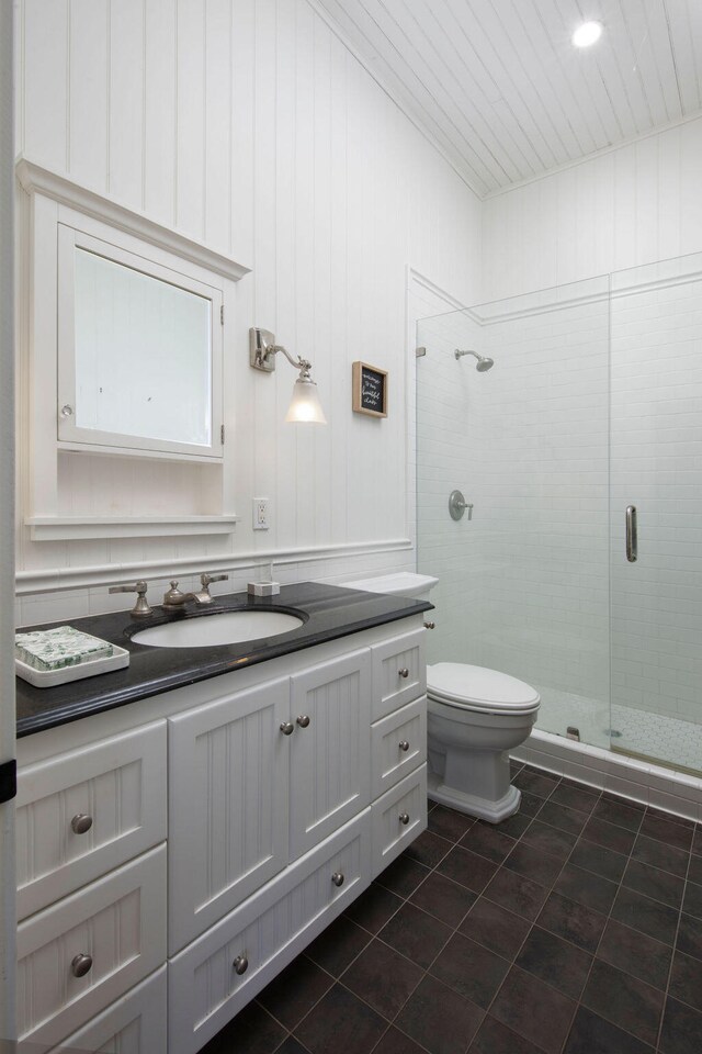 bathroom with a shower with door, vanity, and toilet