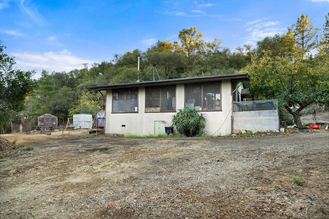 view of property exterior with a storage unit