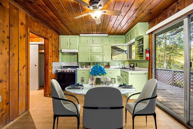 dining area with ceiling fan, sink, light hardwood / wood-style flooring, wood walls, and wood ceiling