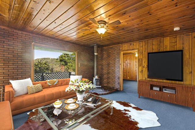 carpeted living room with brick wall, wood ceiling, wooden walls, and a wood stove