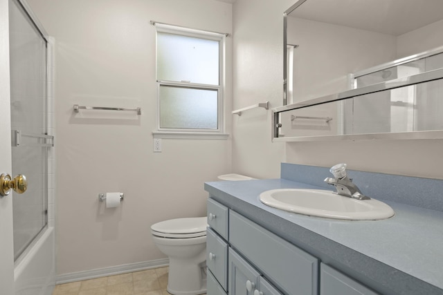 full bathroom featuring tile flooring, enclosed tub / shower combo, toilet, and vanity with extensive cabinet space