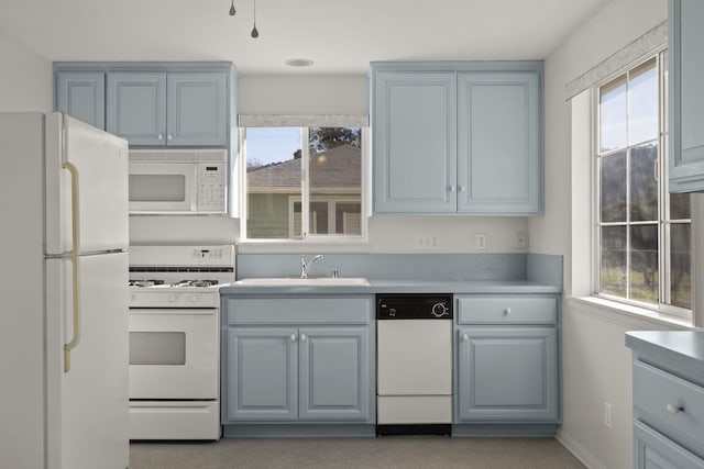 kitchen with white appliances, sink, gray cabinetry, and a healthy amount of sunlight