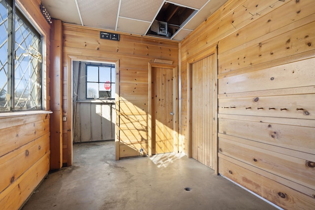 interior space with concrete floors and wood walls