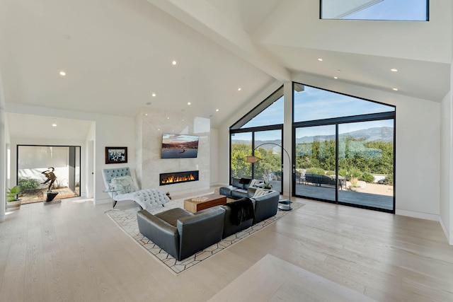 living room featuring light hardwood / wood-style flooring, high vaulted ceiling, a large fireplace, and beamed ceiling