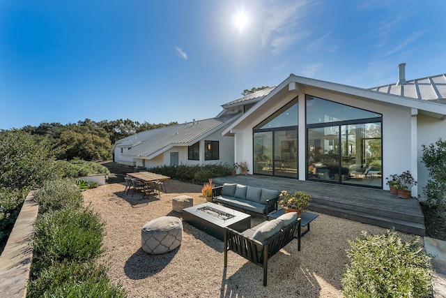 view of patio / terrace with a deck and an outdoor living space with a fire pit