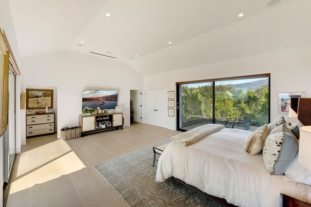 bedroom with lofted ceiling, access to exterior, and light hardwood / wood-style floors